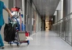 Reinigungswagen mit Eimern und Wischgeräten im Flur eines Gebäudes